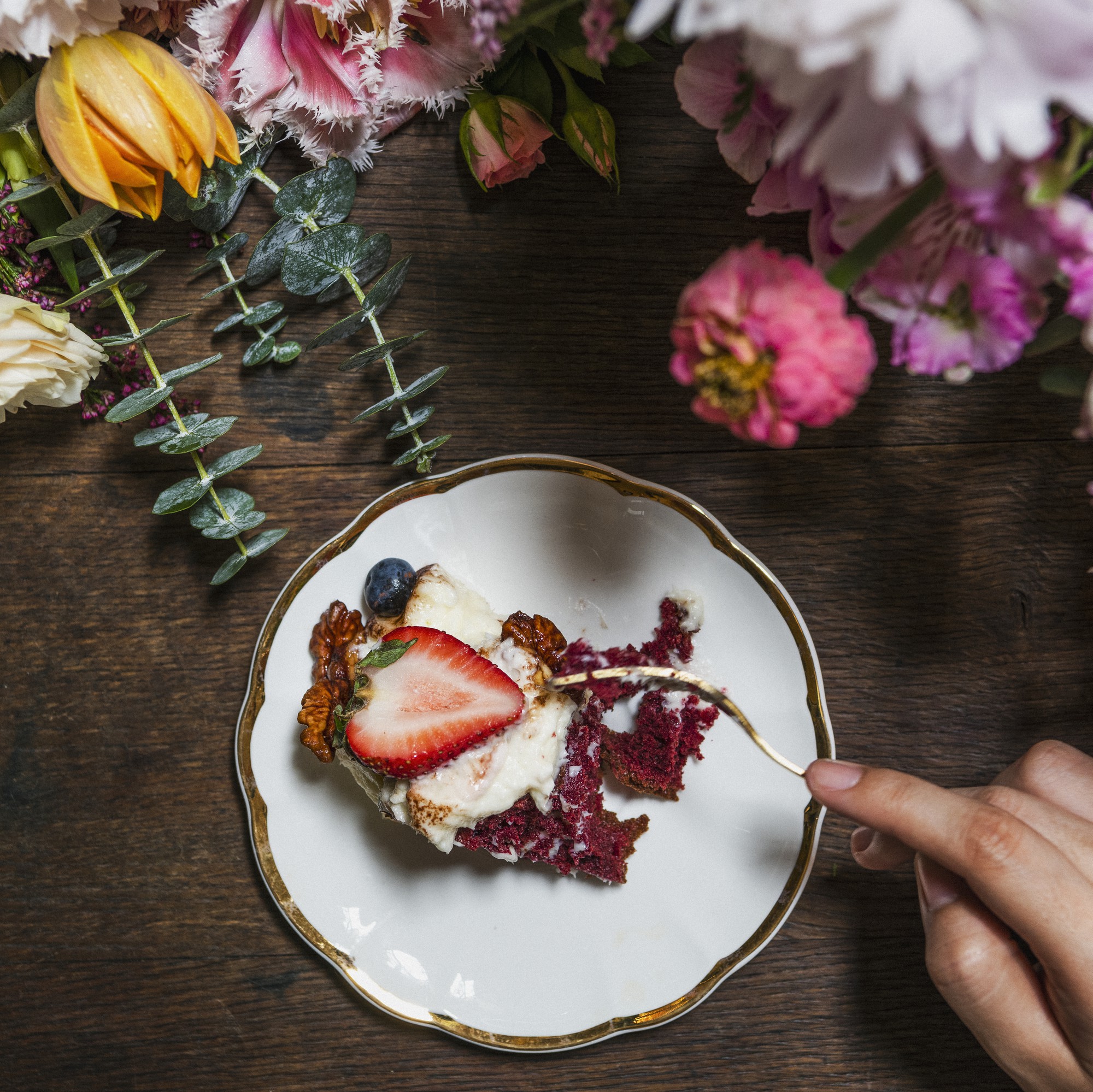 close-up of hands garnishing a plated dessert